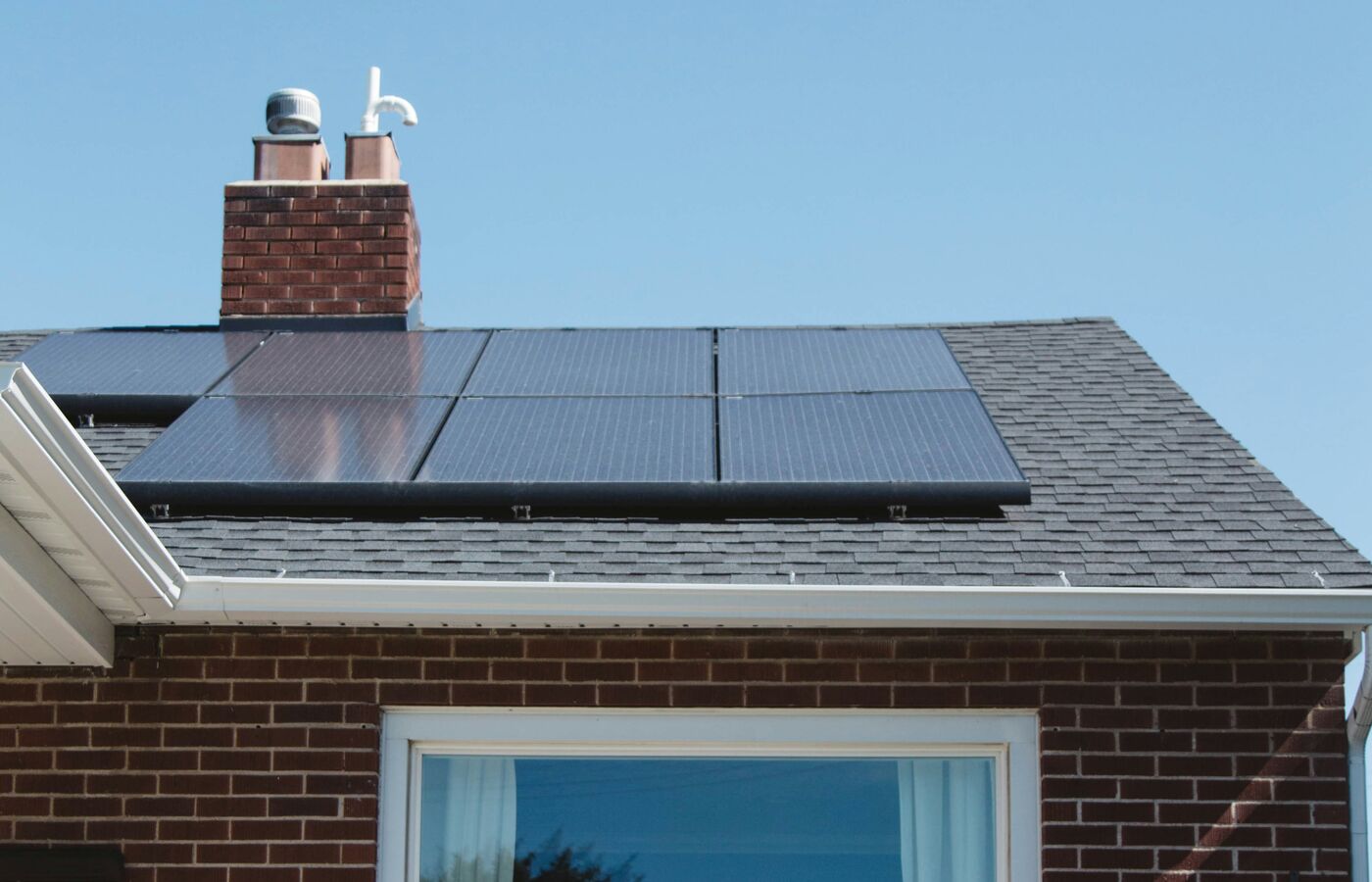 Family home with rooftop solar panels, an ideal energy source to power a shared EV charger.